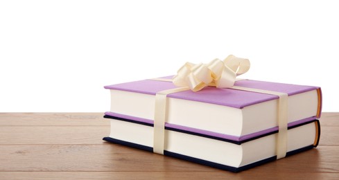 Photo of Hardcover books with ribbon as gift on wooden table against white background