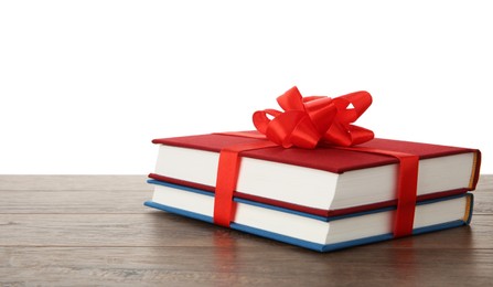 Photo of Hardcover books with ribbon as gift on wooden table against white background