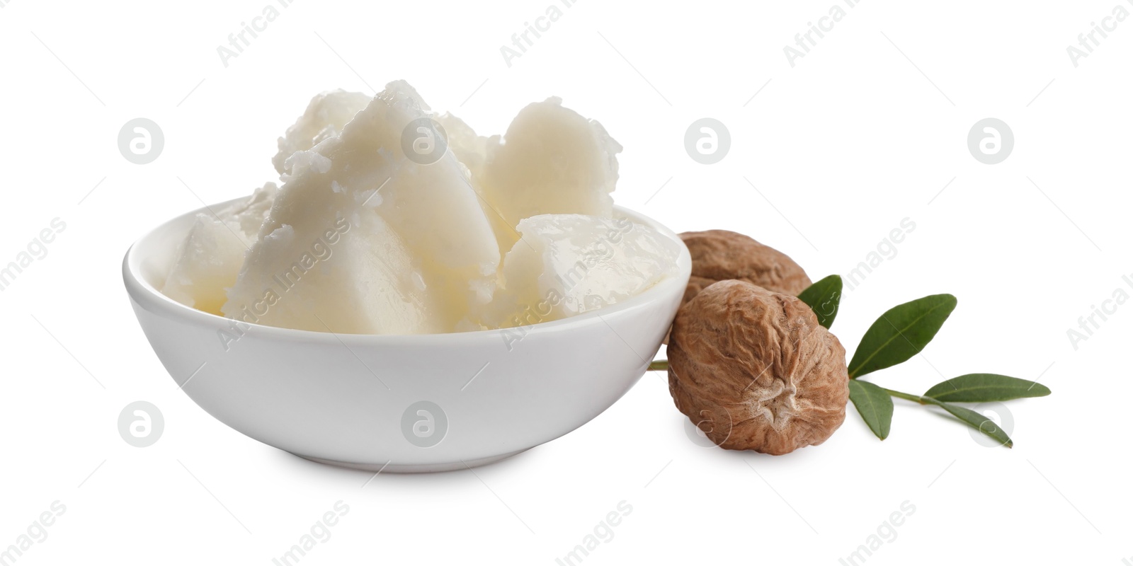 Photo of Natural shea butter in bowl, nuts and green twig isolated on white