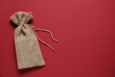 Photo of One burlap sack on red background, top view. Space for text