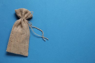 One burlap sack on light blue background, top view. Space for text