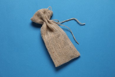 Photo of One burlap sack on light blue background, top view