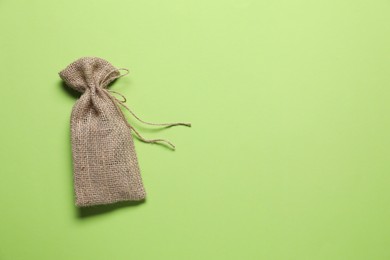 One burlap sack on light green background, top view. Space for text