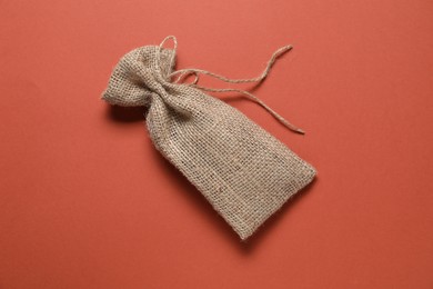 One burlap sack on color background, top view