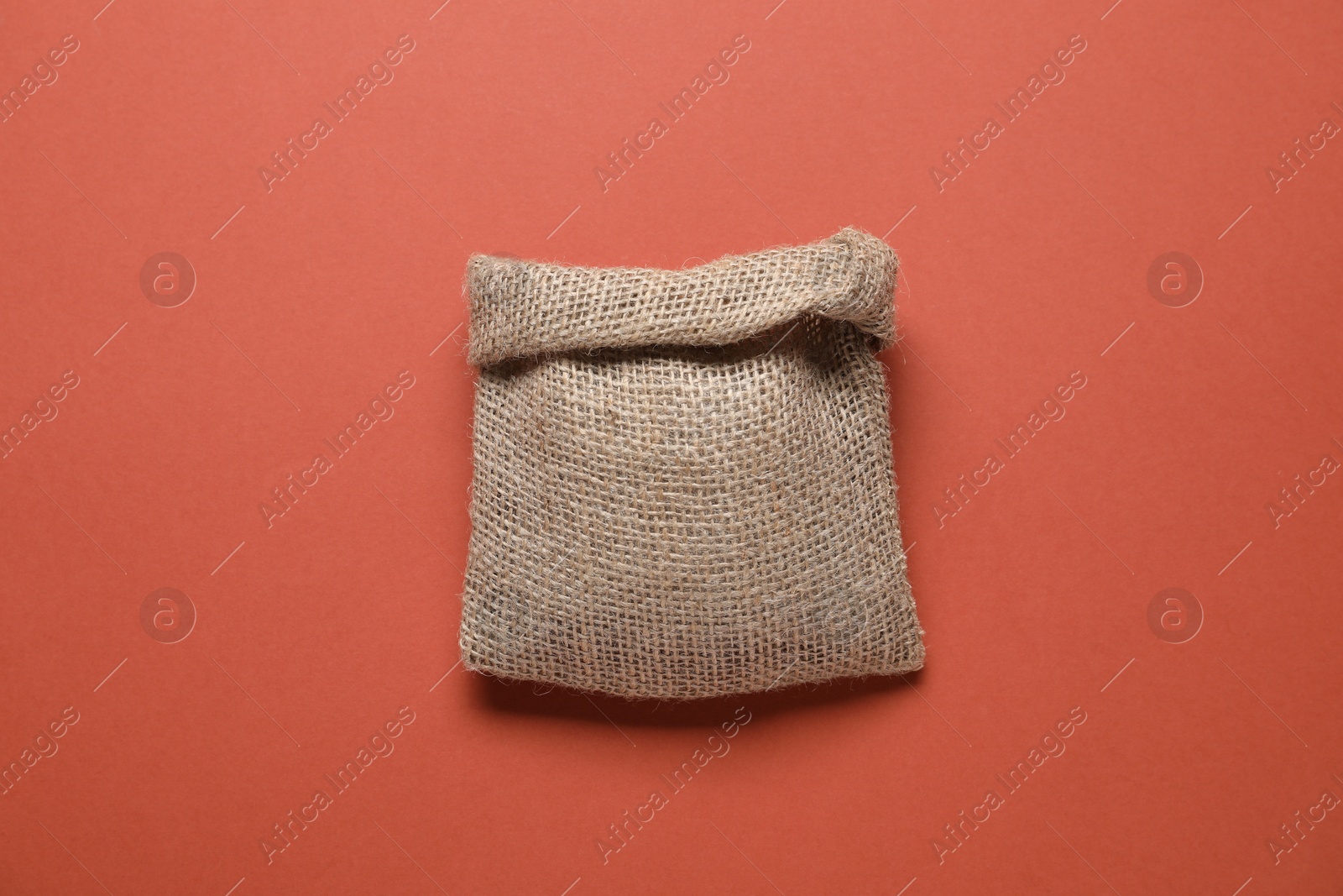 Photo of One burlap sack on color background, top view