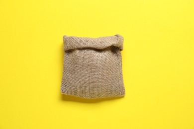 One burlap sack on yellow background, top view