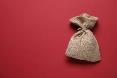 Photo of One burlap sack on red background, top view. Space for text