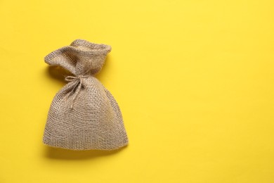 One burlap sack on yellow background, top view. Space for text