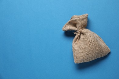 One burlap sack on light blue background, top view. Space for text