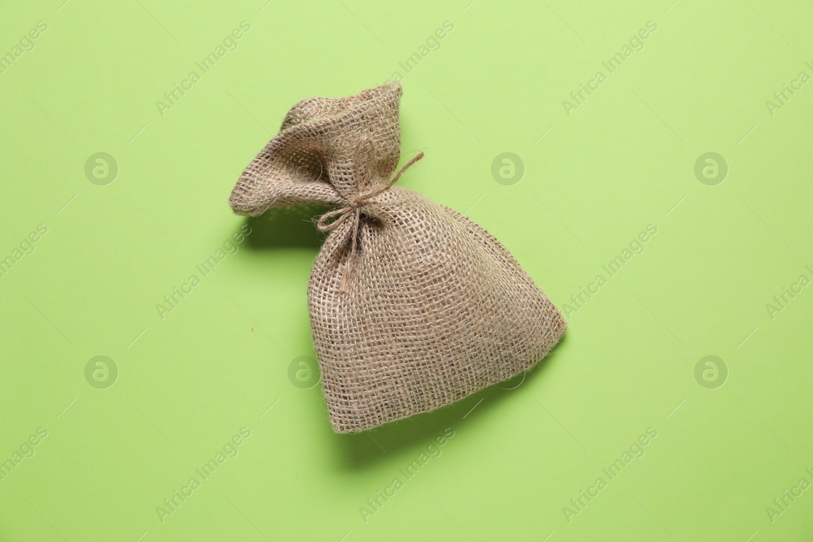 Photo of One burlap sack on green background, top view