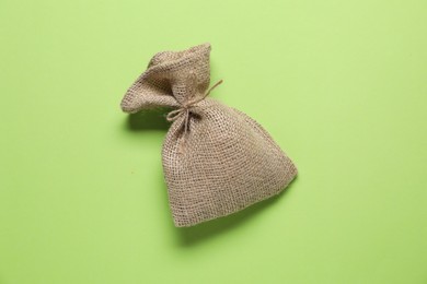 One burlap sack on green background, top view