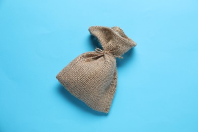 Photo of One burlap sack on light blue background, top view