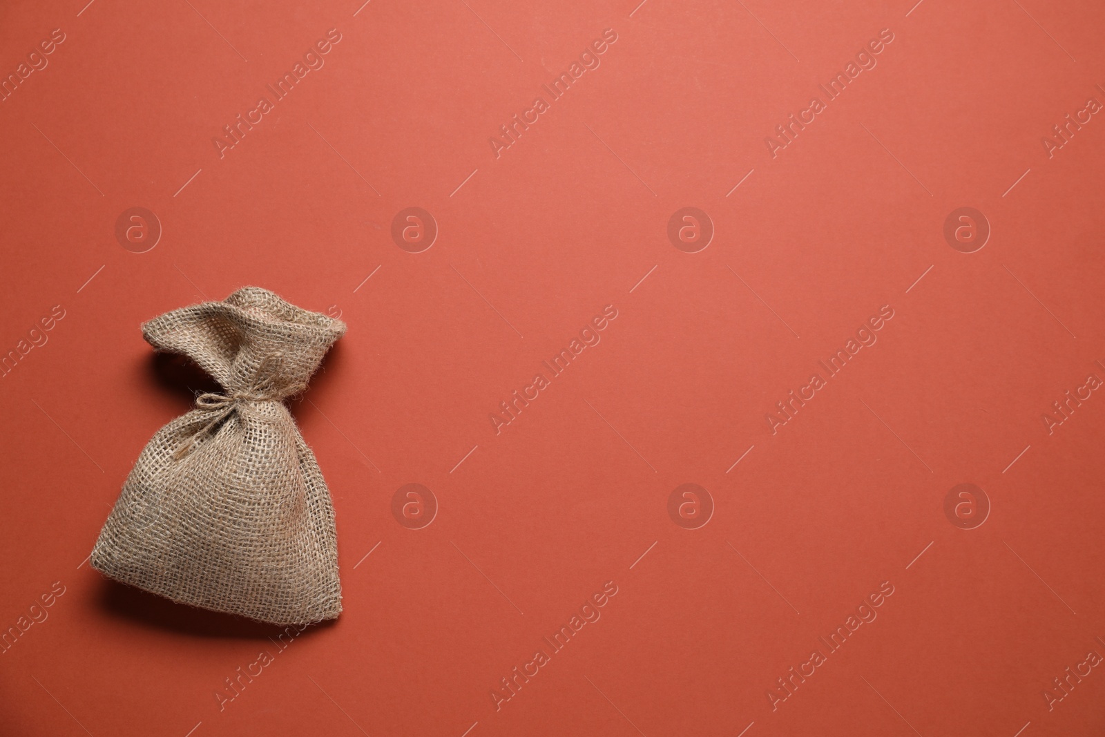 Photo of One burlap sack on color background, top view. Space for text