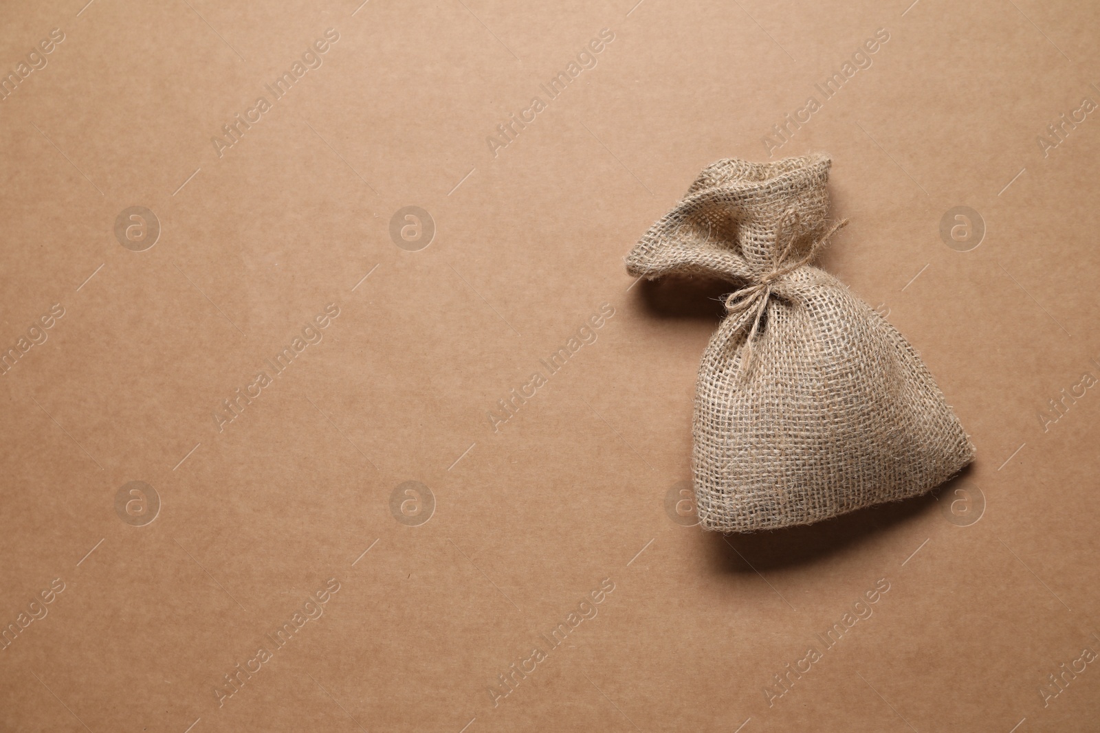 Photo of One burlap sack on beige background, top view. Space for text