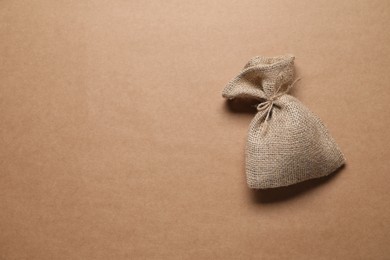 One burlap sack on beige background, top view. Space for text