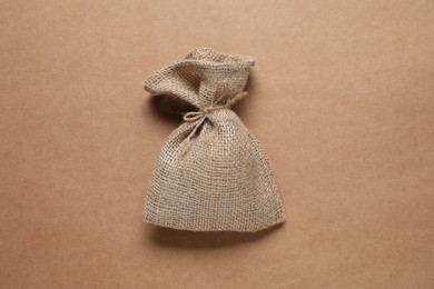 One burlap sack on beige background, top view