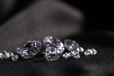 Many beautiful shiny diamonds on black fabric, closeup