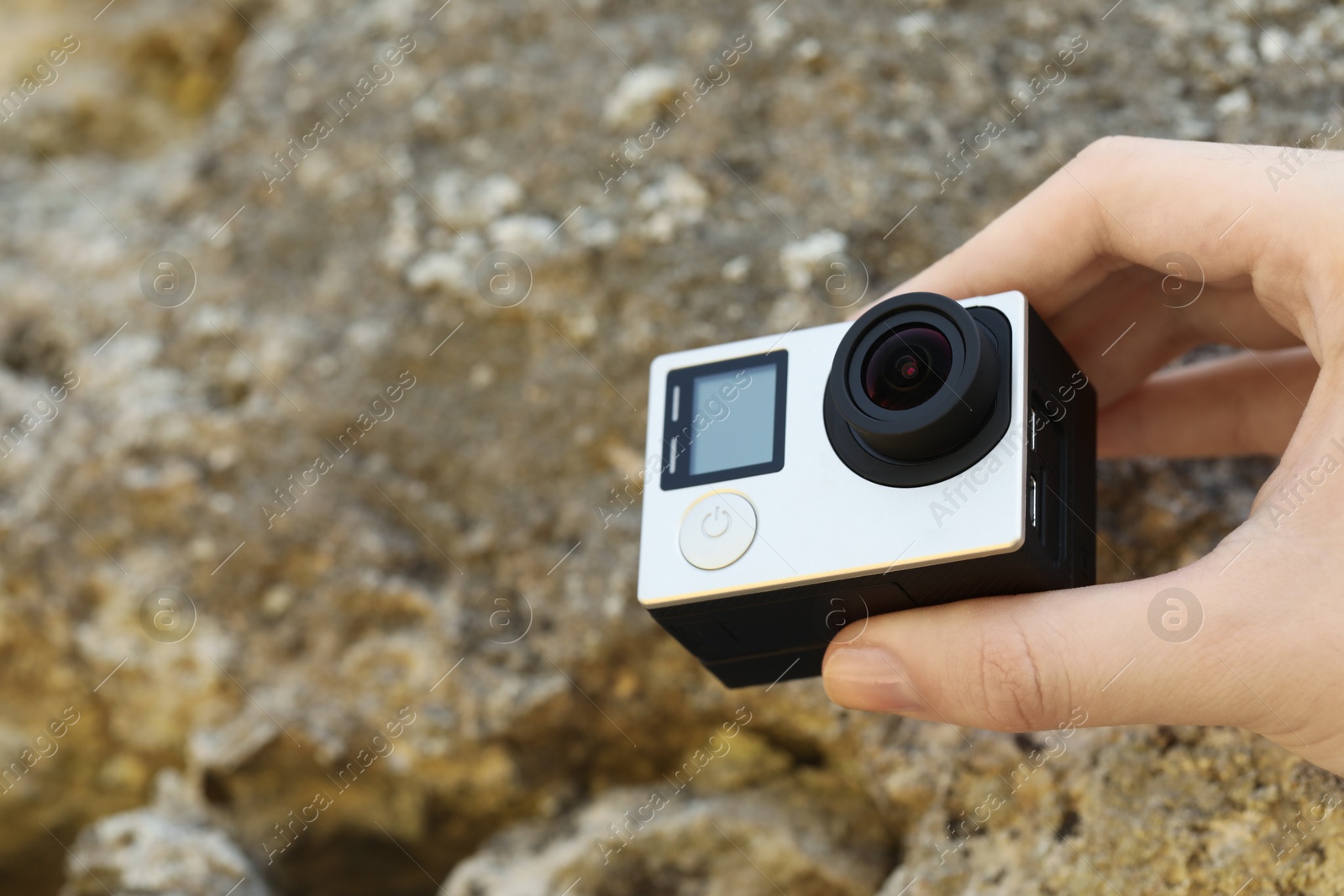 Photo of Man with modern action camera near stones, closeup