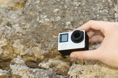 Photo of Man with modern action camera near stones, closeup