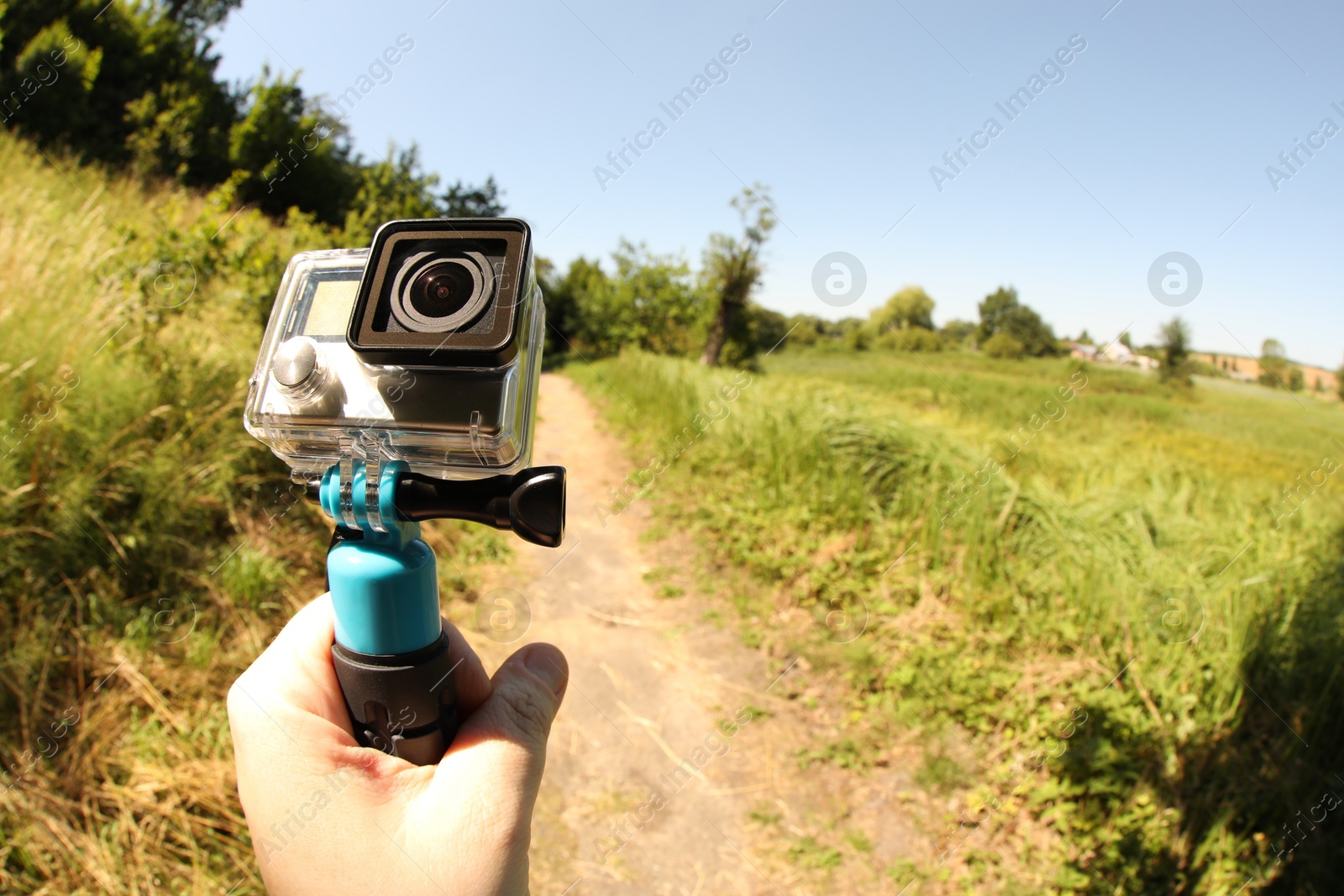 Photo of Man holding monopod with modern action camera outdoors, closeup. Space for text