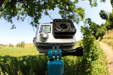 Modern action camera with monopod outdoors. Fisheye lens effect