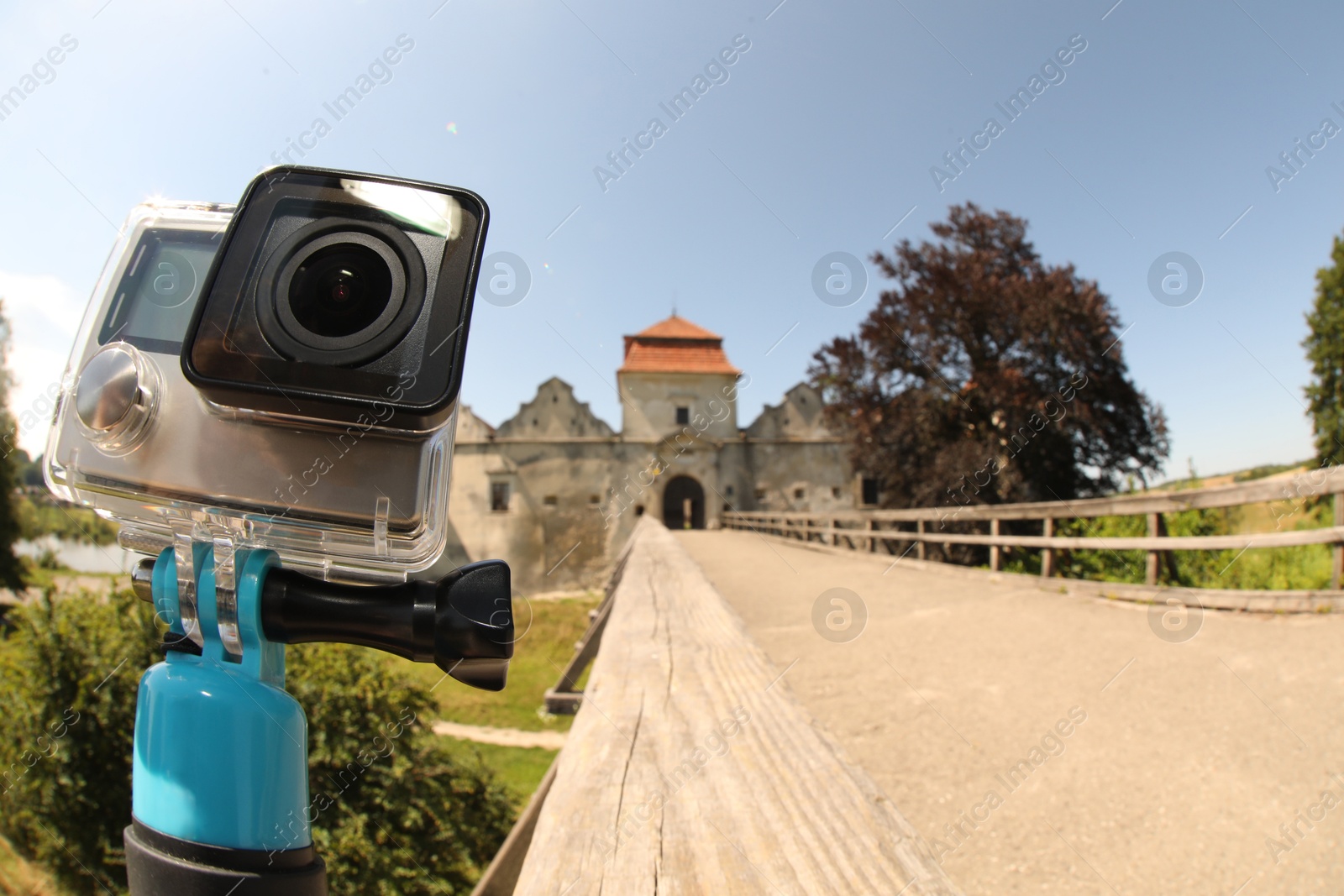 Photo of Modern action camera with monopod outdoors, space for text. Fisheye lens effect