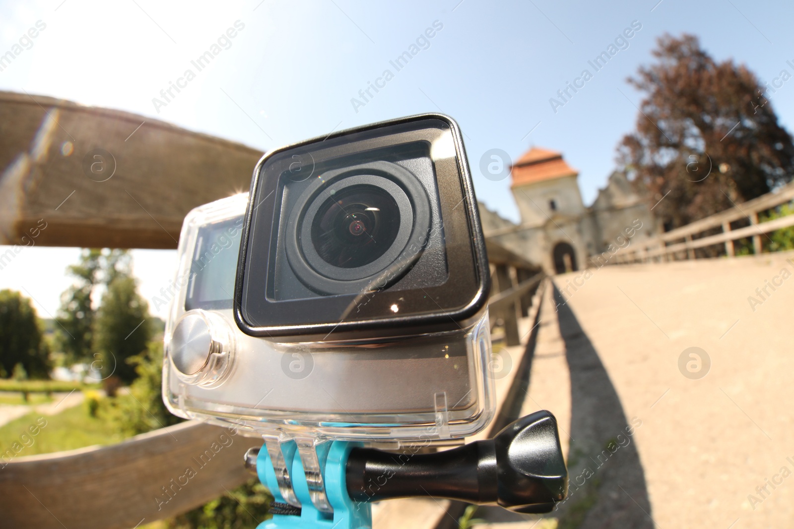 Photo of Modern action camera with monopod outdoors, closeup. Fisheye lens effect