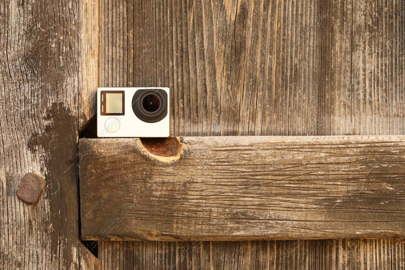 Photo of One modern action camera on wooden surface