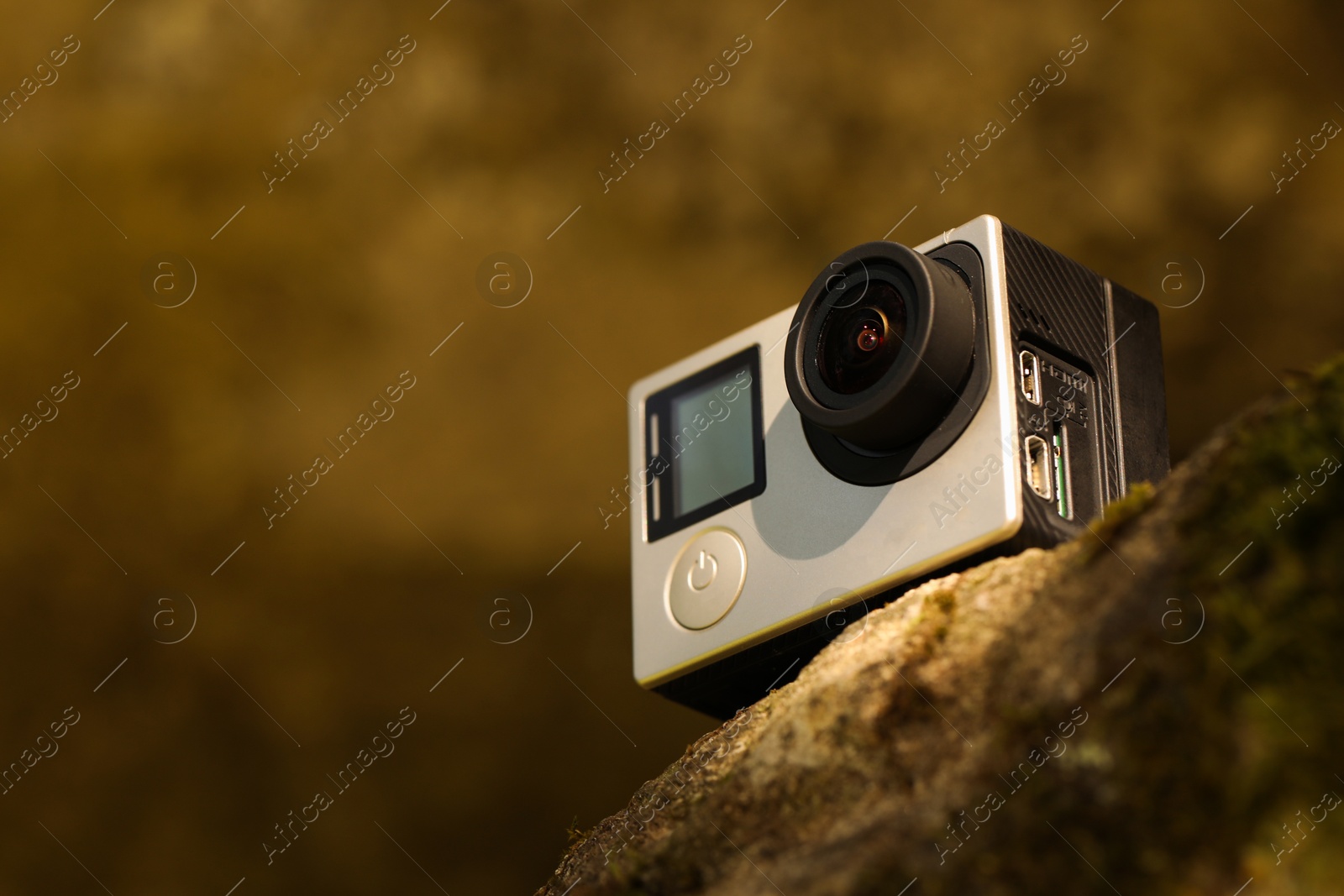 Photo of Modern action camera on stone, closeup. Space for text