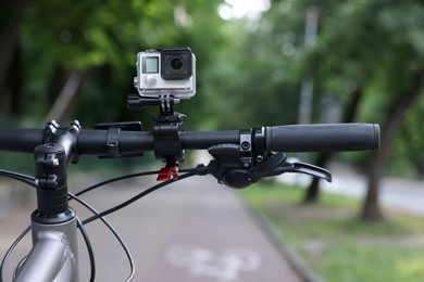 Modern action camera with mount on bicycle outdoors, closeup