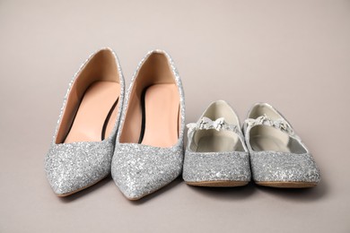 Big and small shoes on grey background