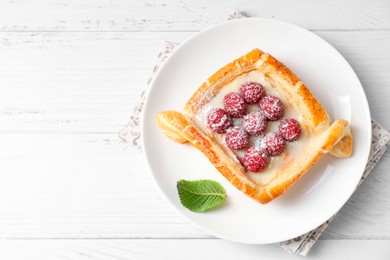 Photo of Tasty puff pastry with raspberries on white wooden table, top view. Space for text