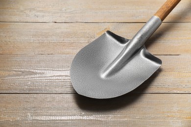 Photo of Metal shovel on wooden table, space for text