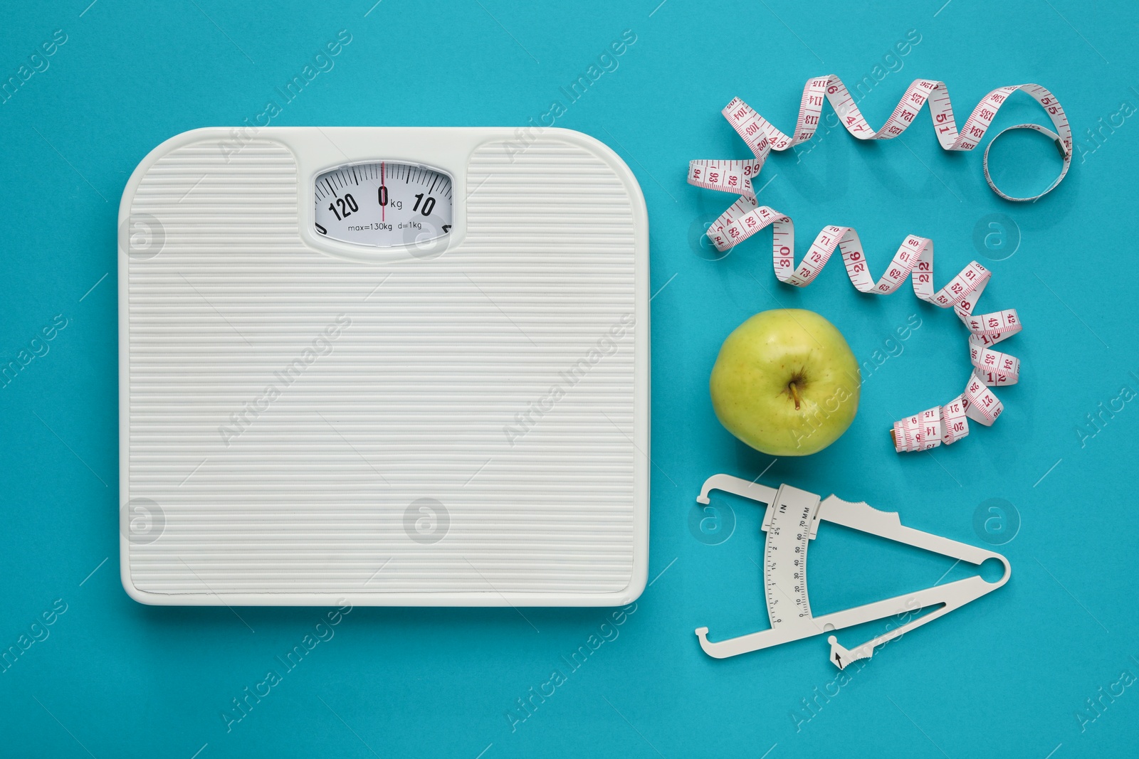 Photo of Body fat caliper, measuring tape, scale and apple on light blue background, flat lay