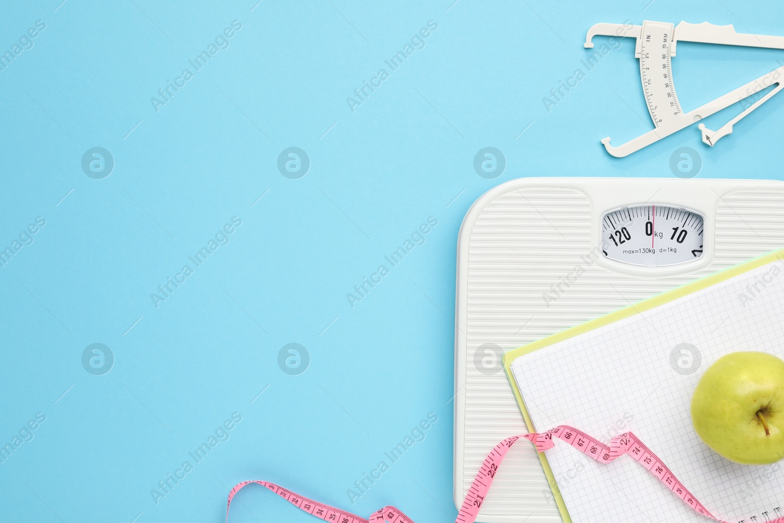 Photo of Flat lay composition with body fat caliper and scale on light blue background. Space for text