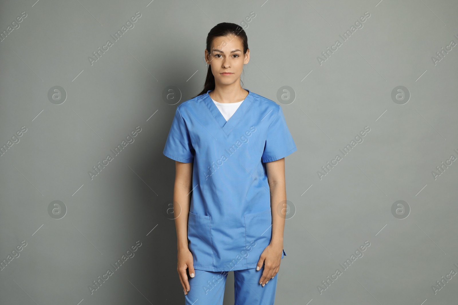 Photo of Portrait of beautiful nurse on grey background