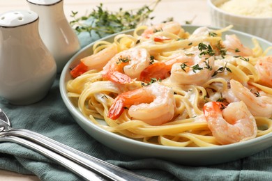 Photo of Delicious pasta with shrimps and creamy sauce served on table, closeup