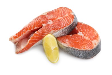 Two fresh salmon steaks and piece of lemon isolated on white