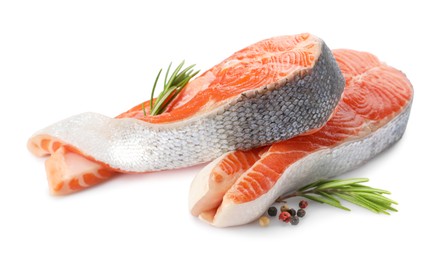 Photo of Two fresh salmon steaks, peppercorns and rosemary isolated on white