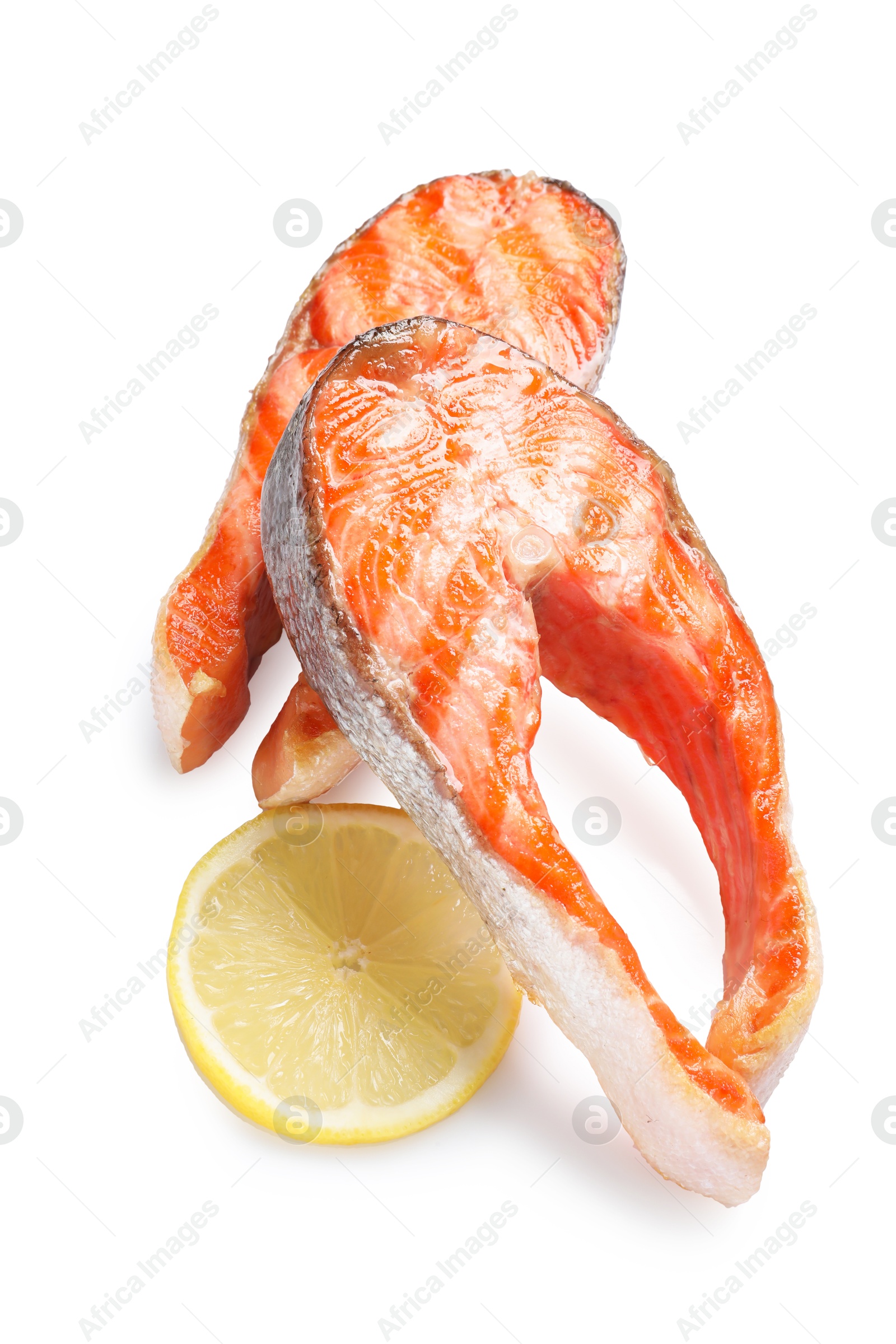 Photo of Tasty grilled salmon steaks and lemon isolated on white, top view