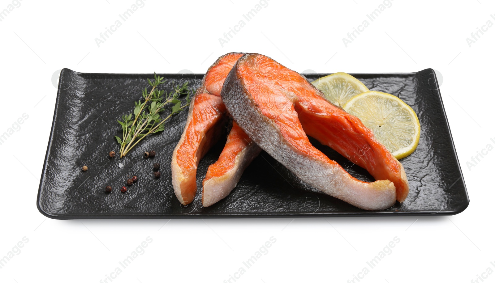 Photo of Tasty grilled salmon steaks, lemon and spices isolated on white