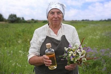 Senior woman with tincture and wildflowers outdoors