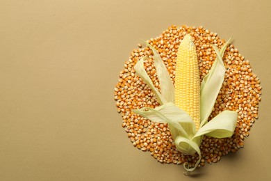 Photo of Fresh ripe corncob and kernels on beige background, top view. Space for text