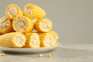 Halves of fresh ripe corncobs on grey table, closeup. Space for text