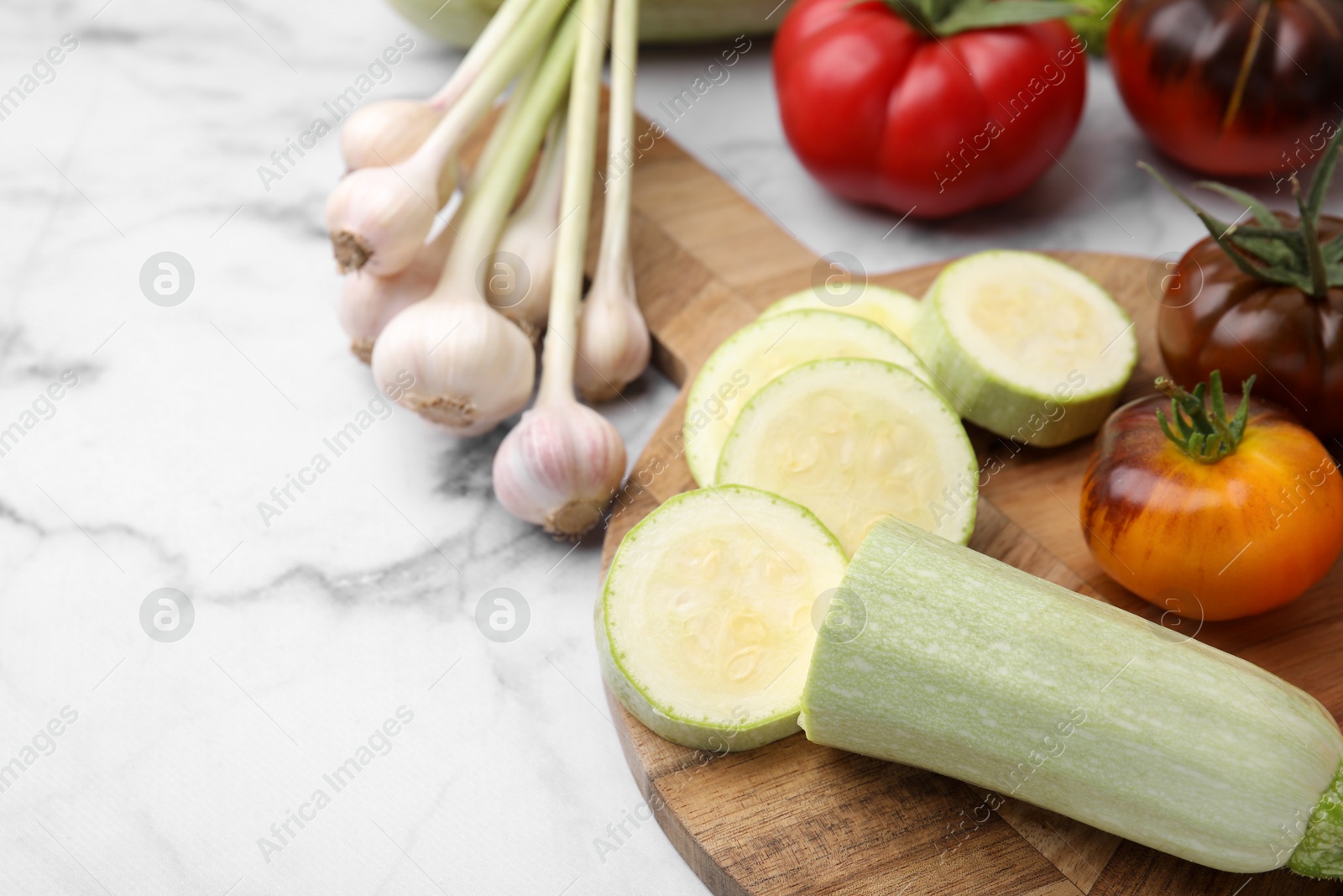 Photo of Cooking tasty stew. Different vegetables on white marble table, space for text