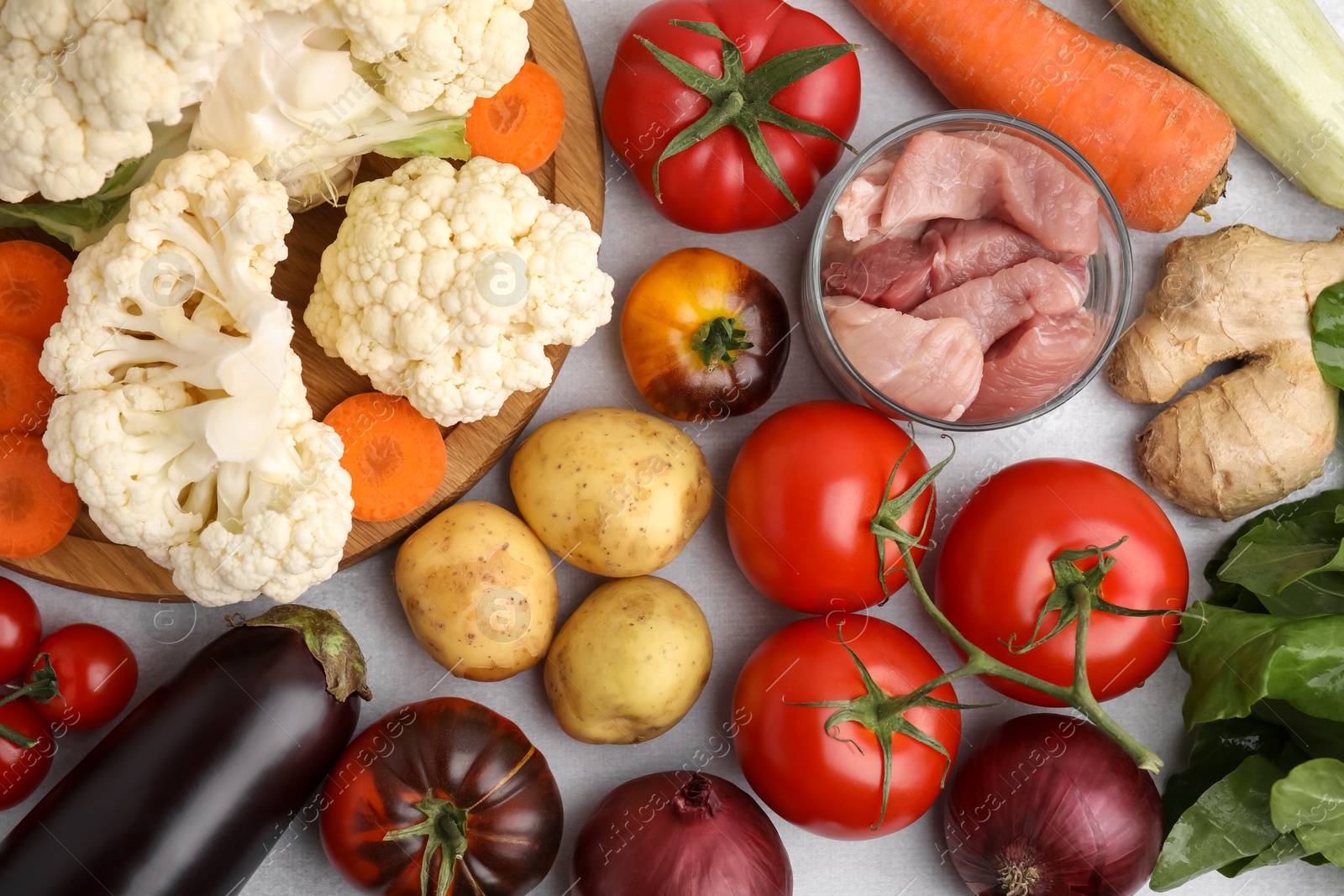 Photo of Different vegetables and raw meat for stew on light grey table, flat lay