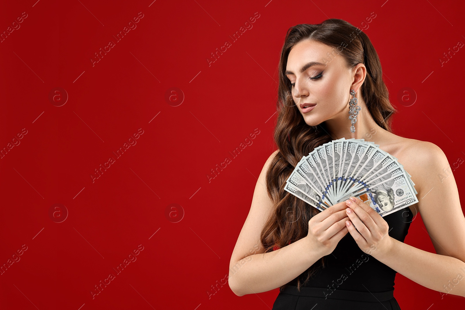 Photo of Charming woman with dollar banknotes on red background. Space for text