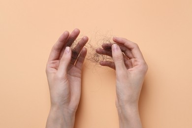 Woman with lost hair on beige background, top view. Alopecia problem