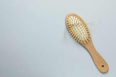 One brush with lost hair on grey background, top view. Space for text