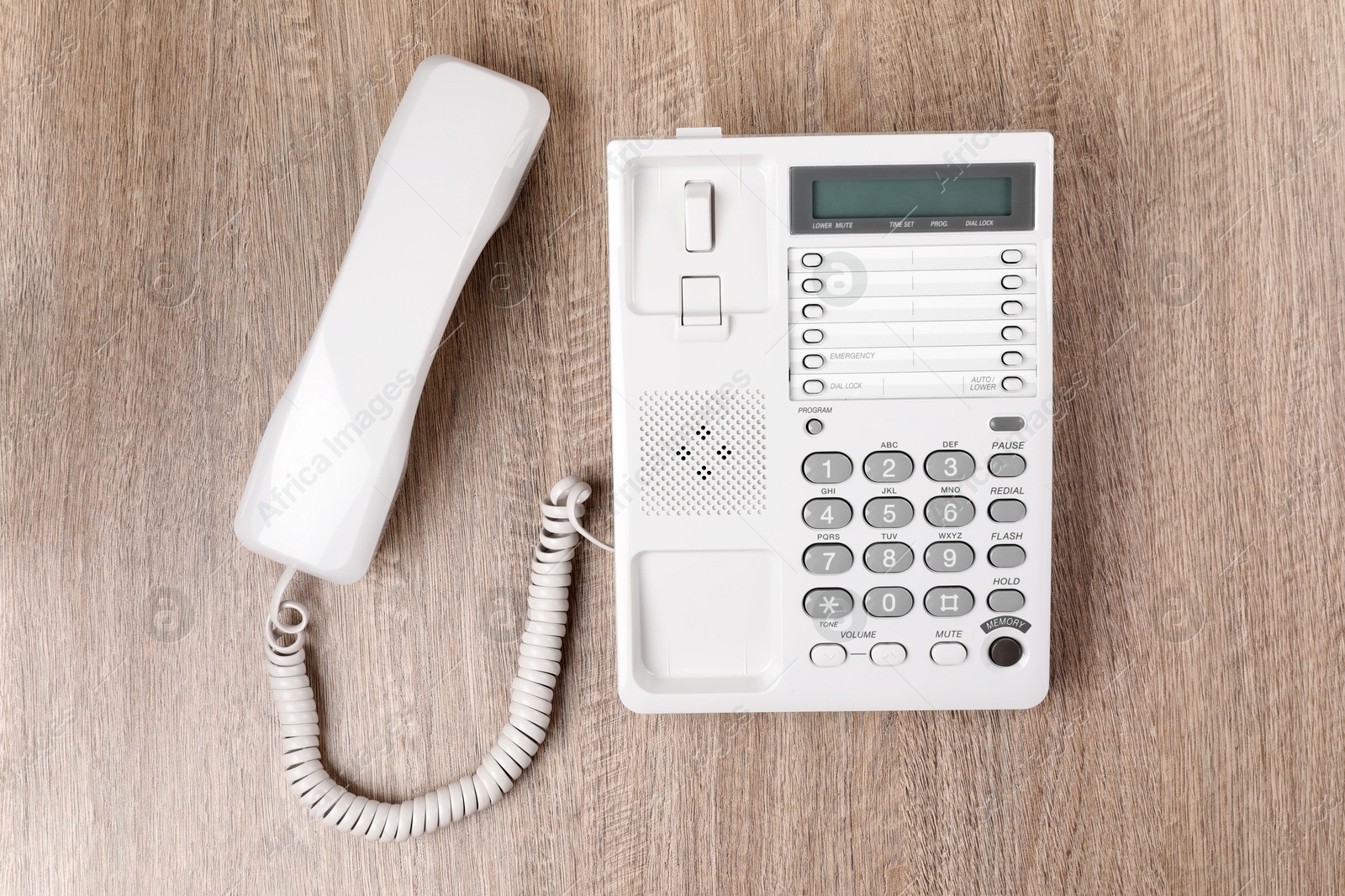 Photo of White telephone on wooden table, top view